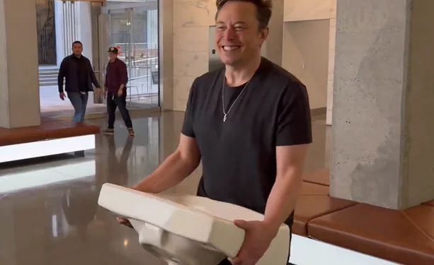 Elon Musk entra sonriente a la sede de Twitter con un lavamanos